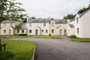Residential buildings with pitched roofs and symmetrical windows line a quiet neighborhood street.