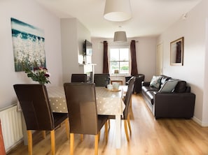 Relax in this stylish living room with a sofa, dining table, and large window.