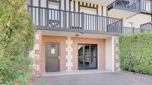 A building with a brick facade, a metal door, and a glass entrance. - Nice apartment for 4 guests with WIFI, TV, balcony and pets allowed (Cabourg)
