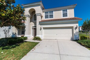 A two-story house with a garage, a front entrance, and a well-maintained lawn.