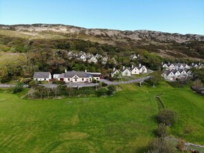 A residential area with houses and a large grassy field.