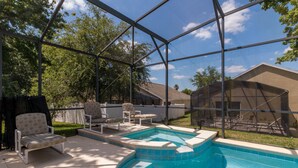 A backyard with a swimming pool, surrounded by a metal fence, and includes outdoor seating and a covered area. - Villa Dodes by VillaDirect (Clermont)