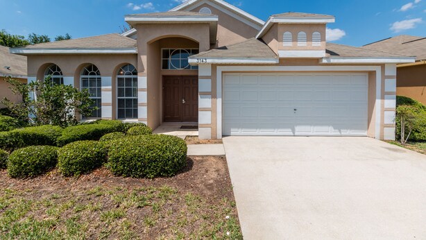 A single-story house with a garage, a front door, and a small porch. - Villa Dodes by VillaDirect (Clermont)