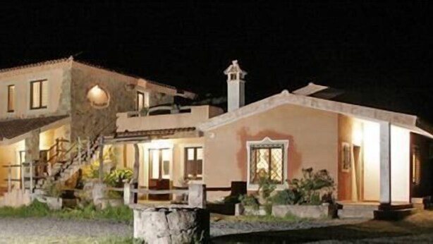 Une maison à deux étages avec un balcon et une cheminée.