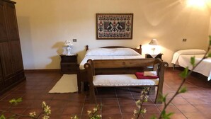 Une chambre à coucher avec un lit en bois, une table de chevet avec une lampe, une décoration murale et un sol carrelé.