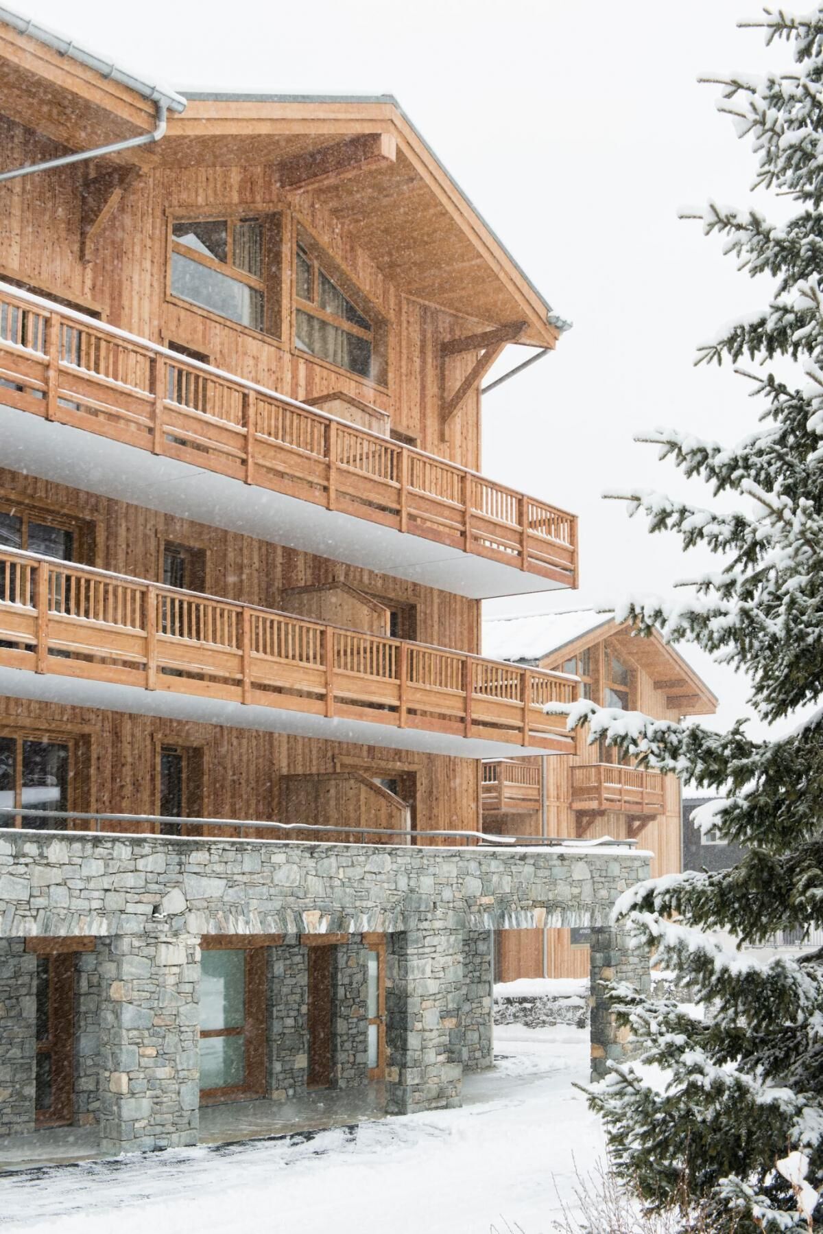 A multi-story wooden building with balconies and a stone base.