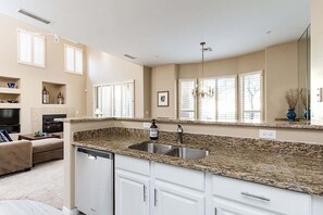 A kitchen with granite countertops, a double sink, white cabinetry, and a large mirror above the sink. - Reduced Rates Just Posted! Cachet Condo (Scottsdale)