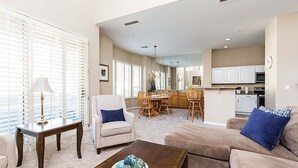 A spacious living room with a sofa, armchair, and coffee table, a dining area with chairs and a table, and a kitchen with cabinets and appliances. - Reduced Rates Just Posted! Cachet Condo (Scottsdale)
