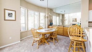 A dining area with a round table, six wooden chairs, and a chandelier. - Reduced Rates Just Posted! Cachet Condo (Scottsdale)