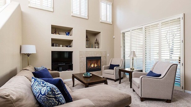 A living room with a fireplace, beige sofas, armchairs, and a TV. - Reduced Rates Just Posted! Cachet Condo (Scottsdale)