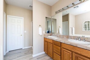 A bathroom with two sinks, wooden cabinets, a large mirror, and a white door. - Reduced Rates Just Posted! Cachet Condo (Scottsdale)