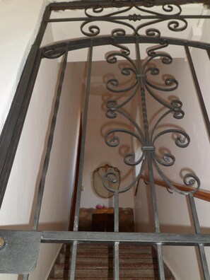 A wrought iron gate with intricate designs, leading to a staircase. - La Dea Bendata (Piazza Armerina)