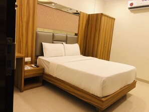 خزنة داخل الغرفة وملاءات أسرّة