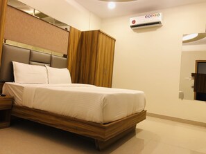 خزنة داخل الغرفة وملاءات أسرّة