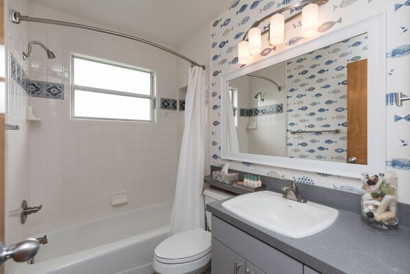 Un baño con bañera, inodoro y lavabo.