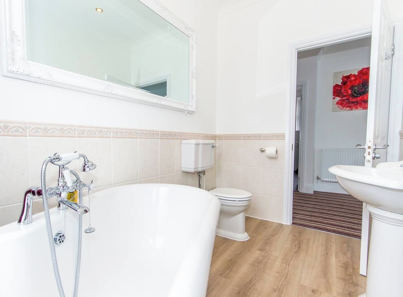 A bathroom with a bathtub, toilet, and sink.