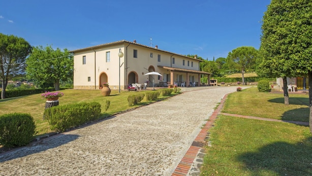 A two-story building with a paved driveway leading to a covered patio area. - Cosy apartment in villa for 7 people with pool, WIFI, TV and pets allowed (Bucine)
