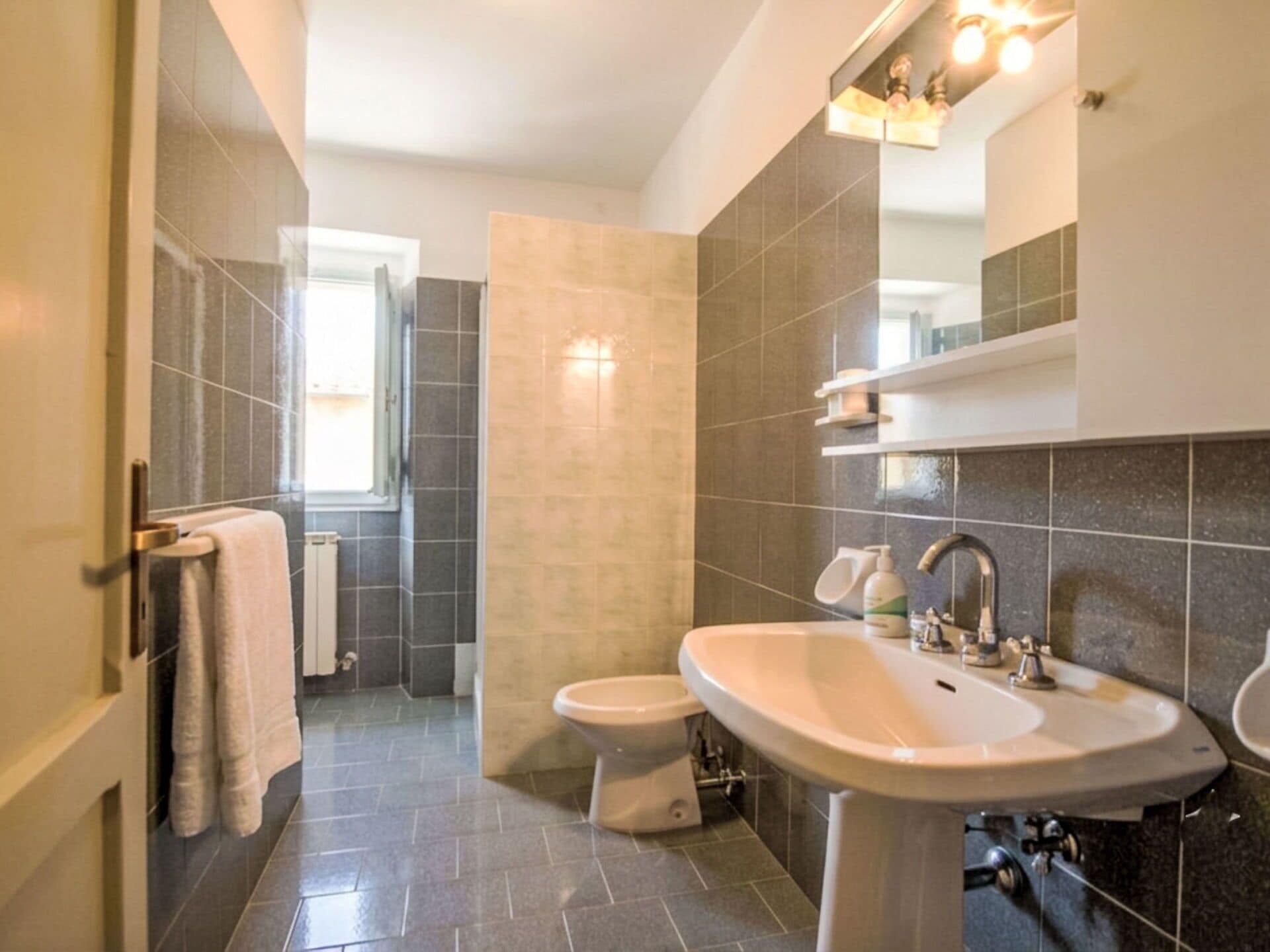 Een moderne badkamer met toilet, wastafel en douchehoek.