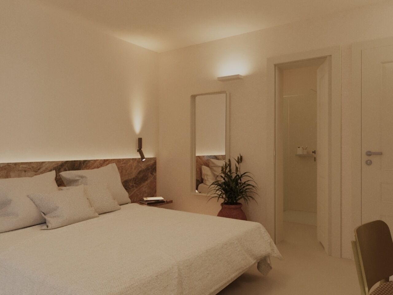 A bedroom with a bed, bedside table, mirror, potted plant, and a door leading to another room.