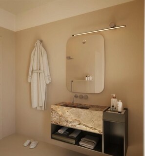 A modern bathroom with a marble sink, a towel rack, and a mirror. - Albergo Ristorante Egadi (Favignana)