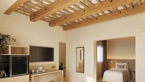 A modern hotel room with a wooden ceiling, a bed, a desk, and a TV.