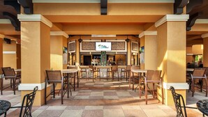 Ulkoterassi, jossa on pöytiä ja tuoleja, baari ja kyltti, jossa lukee ”The Resort”.