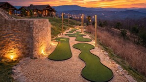 A golf course with a winding path, stone walls, and a sunset view. - Misty Bluff - Indoor pool & mountain views (Sevierville)