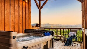 A wooden deck with a hot tub, a chair, and a view of the mountains. - Misty Bluff - Indoor pool & mountain views (Sevierville)