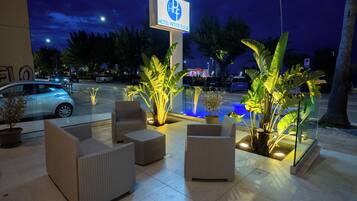 Señal de hotel, zona de estar al aire libre y piscina.