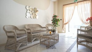Una habitación con muebles de mimbre, una mesita de centro y una planta en maceta.