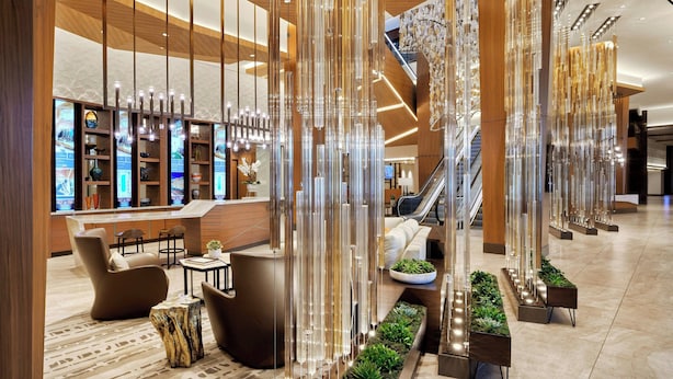 A modern lobby with a reception desk, seating area, and a staircase. - JW Marriott Anaheim Resort (Anaheim)