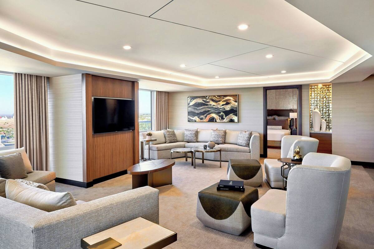 A modern living room with a sofa set, a flat-screen TV, and a coffee table.