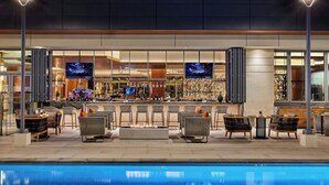 A bar area with seating and a pool in the foreground. - JW Marriott Anaheim Resort (Anaheim)