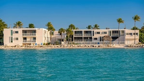 Een strandhotel met meerdere verdiepingen, balkons en een zwembad.