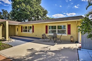 A single-story house with a covered patio, a dining table with chairs, and a small statue. - 8 Mi to Universal: Orlando Studio w/ Fire Pit! (Orlando)