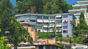 A multi-story hotel with balconies, surrounded by trees. - Nice apartment for 4 people with WIFI, TV, balcony and pets allowed (Ascona)