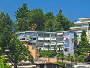 Ein mehrstöckiges Hotel mit Balkonen, umgeben von Bäumen.