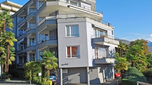 A multi-story building with balconies, a garage, and a sign indicating it is a hotel.