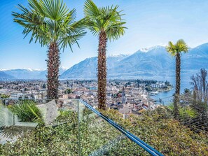 A panoramic view of a coastal city with mountains in the background, palm trees, and a clear sky. - Lovely apartment for 2 guests with WIFI, TV, balcony and pets allowed (Ascona)