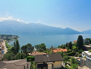A coastal town with buildings near a large body of water, surrounded by mountains.