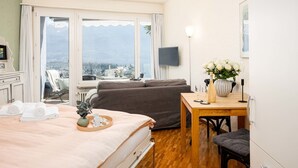 Hotellihuone, jossa on sänky, sohva, ruokapöytä ja televisio.