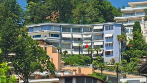 A multi-story hotel with balconies, surrounded by trees and other buildings. - Lovely apartment for 2 people with WIFI, TV, balcony and pets allowed (Ascona)