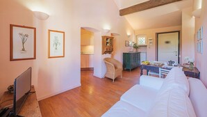 Una camera accogliente con un letto, una TV e un'area pranzo con tavolo e sedie.