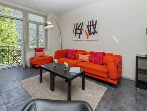 A modern living room with a sofa, a coffee table, and a large window.