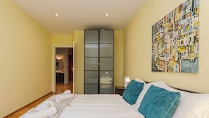 Een hotelkamer met een groot bed, een kledingkast en een schilderij aan de muur.