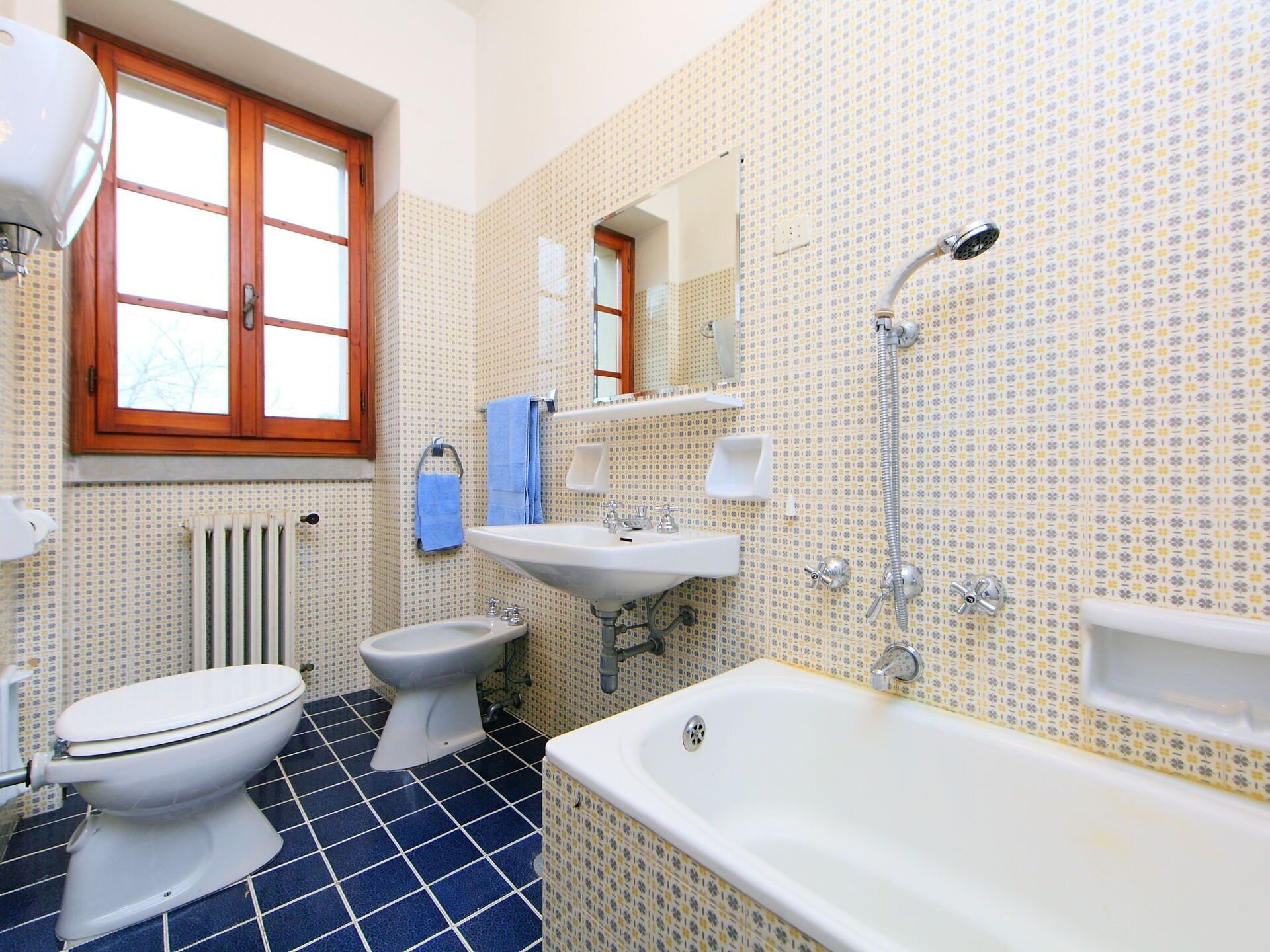 Un baño con inodoro, bidé, lavabo y bañera.