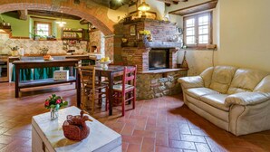 Un intérieur rustique avec une cheminée en pierre, des meubles en bois et un canapé en cuir.