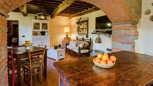 Une cuisine rustique avec des arches en briques apparentes, des poutres en bois et un mur en pierre.