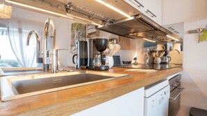 Une cuisine moderne dotée d’appareils électroménagers en acier inoxydable, d’un plan de travail en bois et d’un lave-vaisselle.