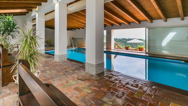 A covered swimming pool area with a view of the outdoors, wooden beams, and tiled flooring. - Nice apartment in villa for 2 guests with WIFI, A/C, pool, patio and panoramic view (Cinigiano)